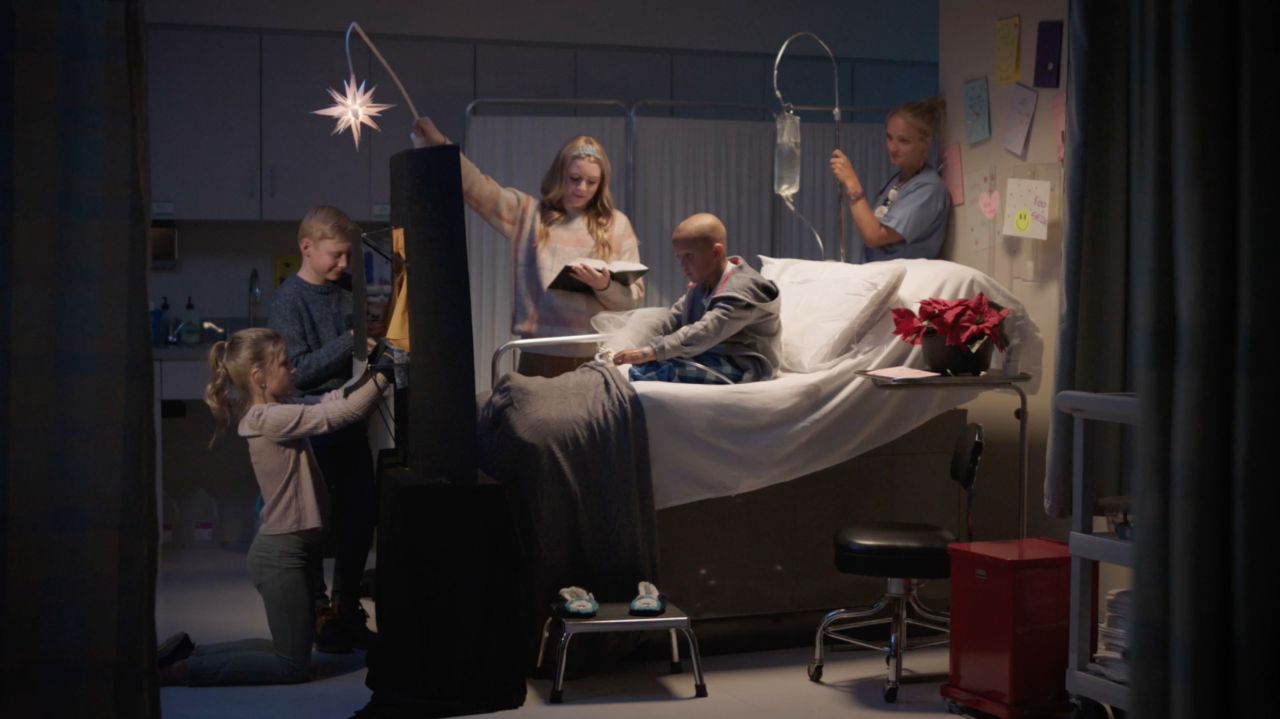 Un grup de copii desfășoară o scenetă cu marionete despre nașterea Domnului pentru o tânără fată bolnavă de cancer