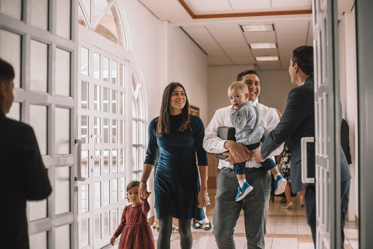 O familie tânără intră într-o clădire a Bisericii pentru a învăța despre Evanghelia lui Isus Hristos.